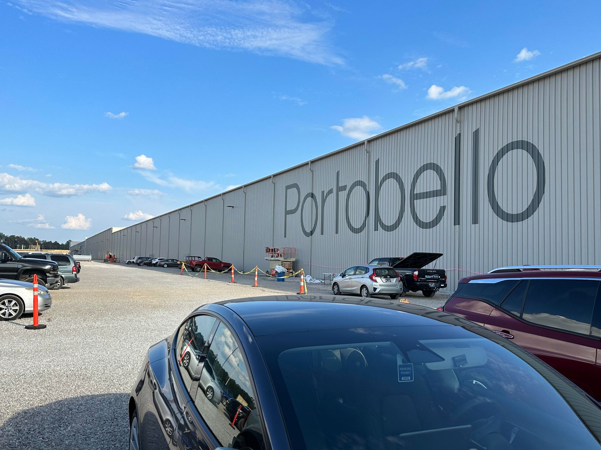 Cars parked near a long building with 