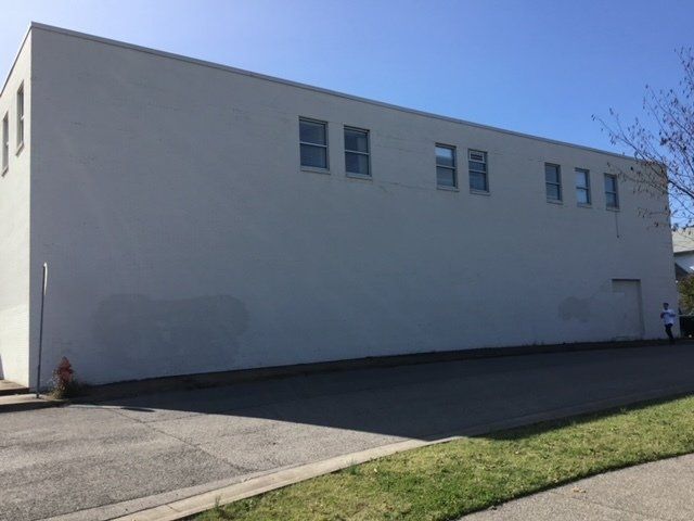 A large white building with a lot of windows and a fire hydrant in front of it.