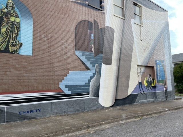 A mural on the side of a building that says charity
