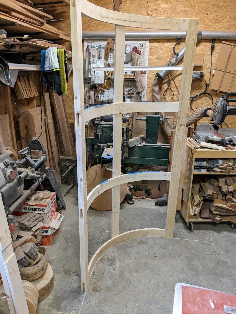 A wooden door is being built in a workshop.
