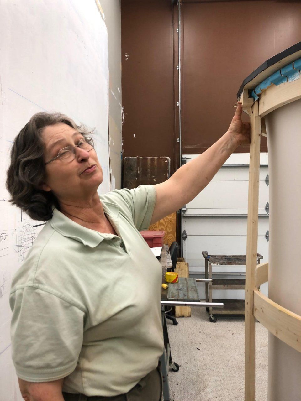 A woman is standing in a room looking at something