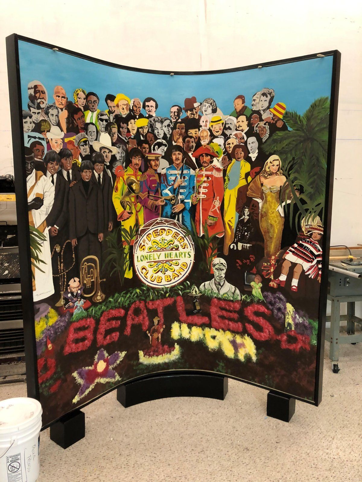 A large painting of the beatles is on display