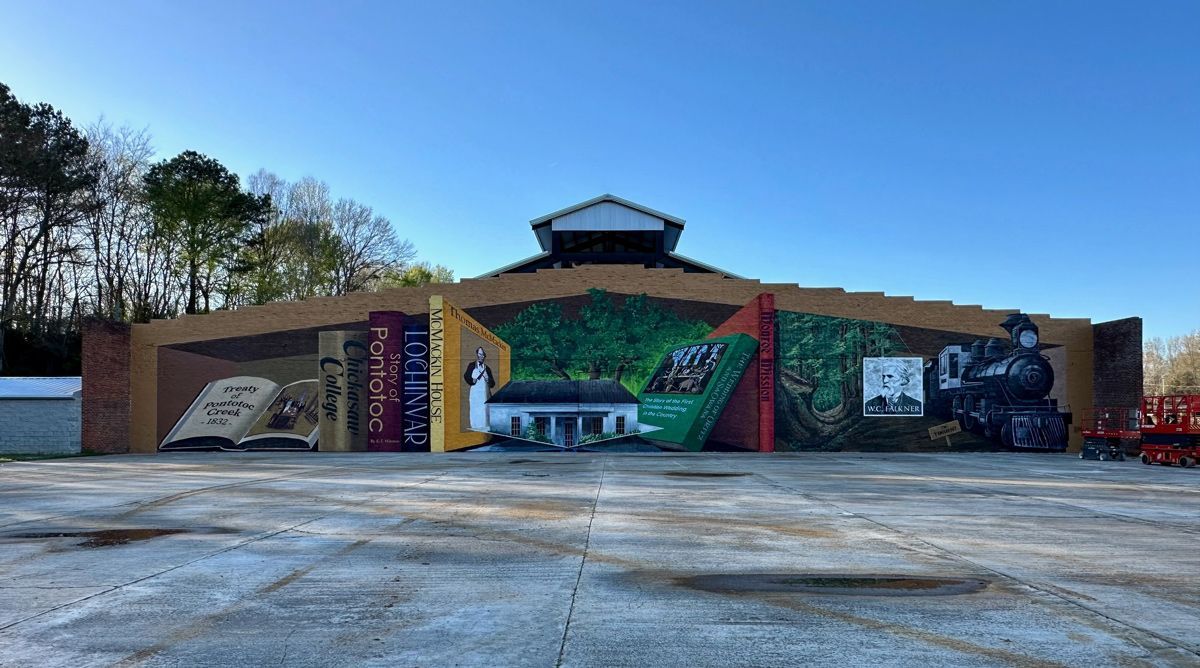 There is a large mural on the side of a building.
