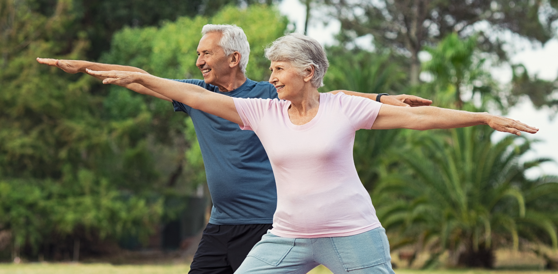 Casal de idosos alongando os braços ao ar livre, representando qualidade de vida após a cirurgia pulmonar