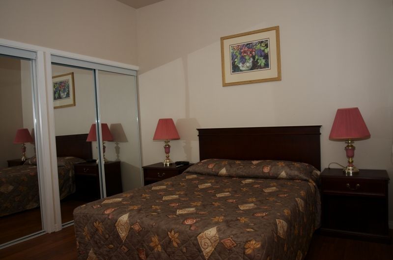 A bedroom with a bed and two lamps