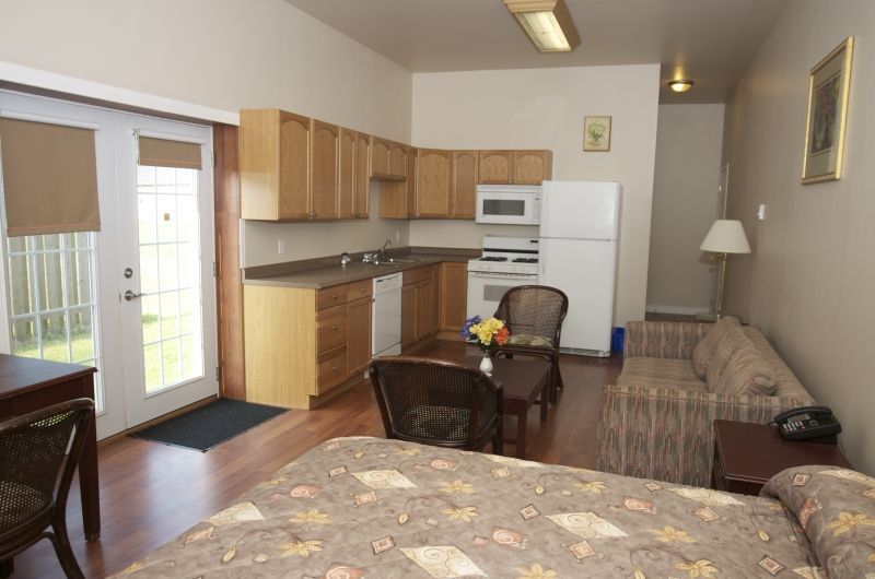 A living room with a couch a table and a refrigerator