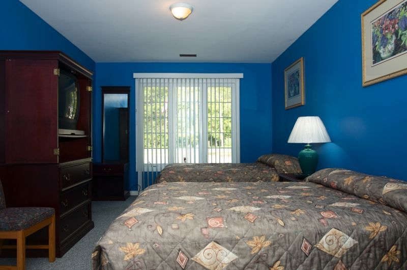 A hotel room with blue walls and two beds