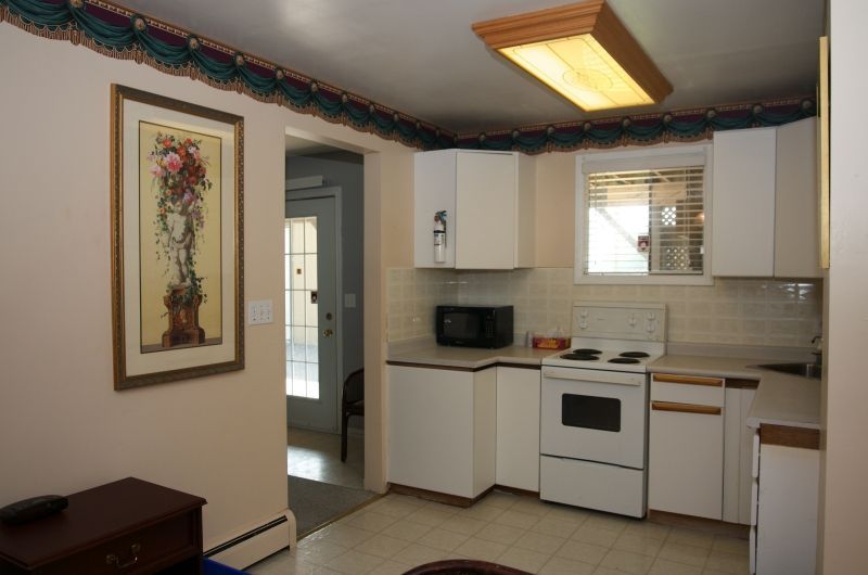 A kitchen with white cabinets a stove and a microwave