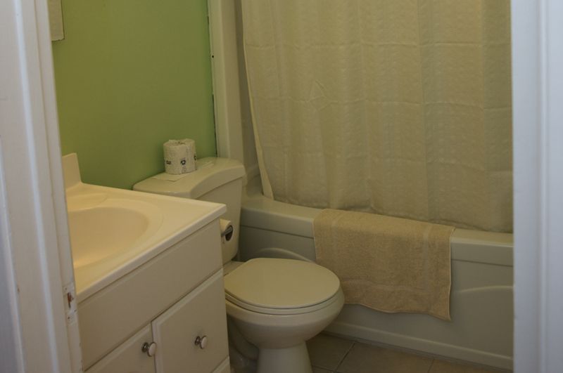 A bathroom with a toilet , sink , and bathtub.