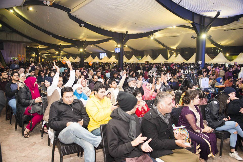 A large group of people are sitting in chairs in a large room.
