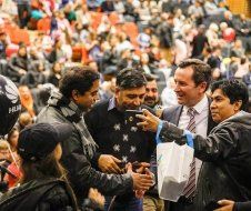 A group of men are standing in front of a crowd of people.