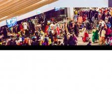 A large group of people are standing in a shopping mall.