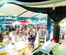 A crowd of people are gathered at a market at night.