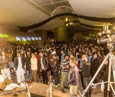A large group of people are standing in front of a stage at a concert.