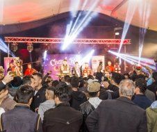 A crowd of people are standing in front of a stage at a concert.