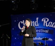 A man is standing on a stage holding a microphone.