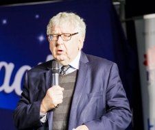 A man in a suit and tie is holding a microphone.