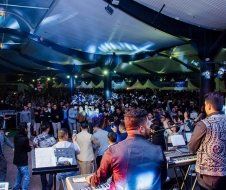A man is playing a keyboard in front of a crowd of people.