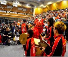A group of people are playing drums in front of a crowd.