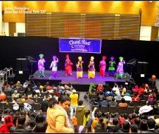 A group of people are dancing on a stage in front of a crowd.