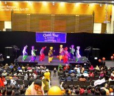 A group of people are dancing on a stage in front of a crowd.