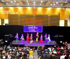 A group of people are dancing on a stage in front of a crowd.