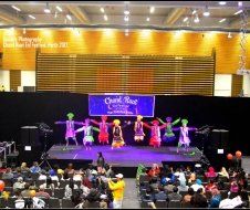 A group of people are dancing on a stage in front of a crowd.