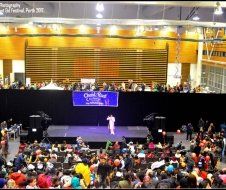 A large crowd of people are watching a performance on a stage.