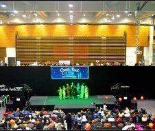 A group of people are standing on a stage in front of a crowd.