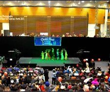 A group of people are dancing on a stage in front of a crowd.