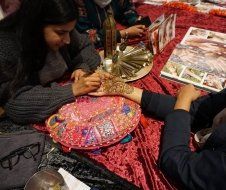 A group of people are sitting at a table making crafts.
