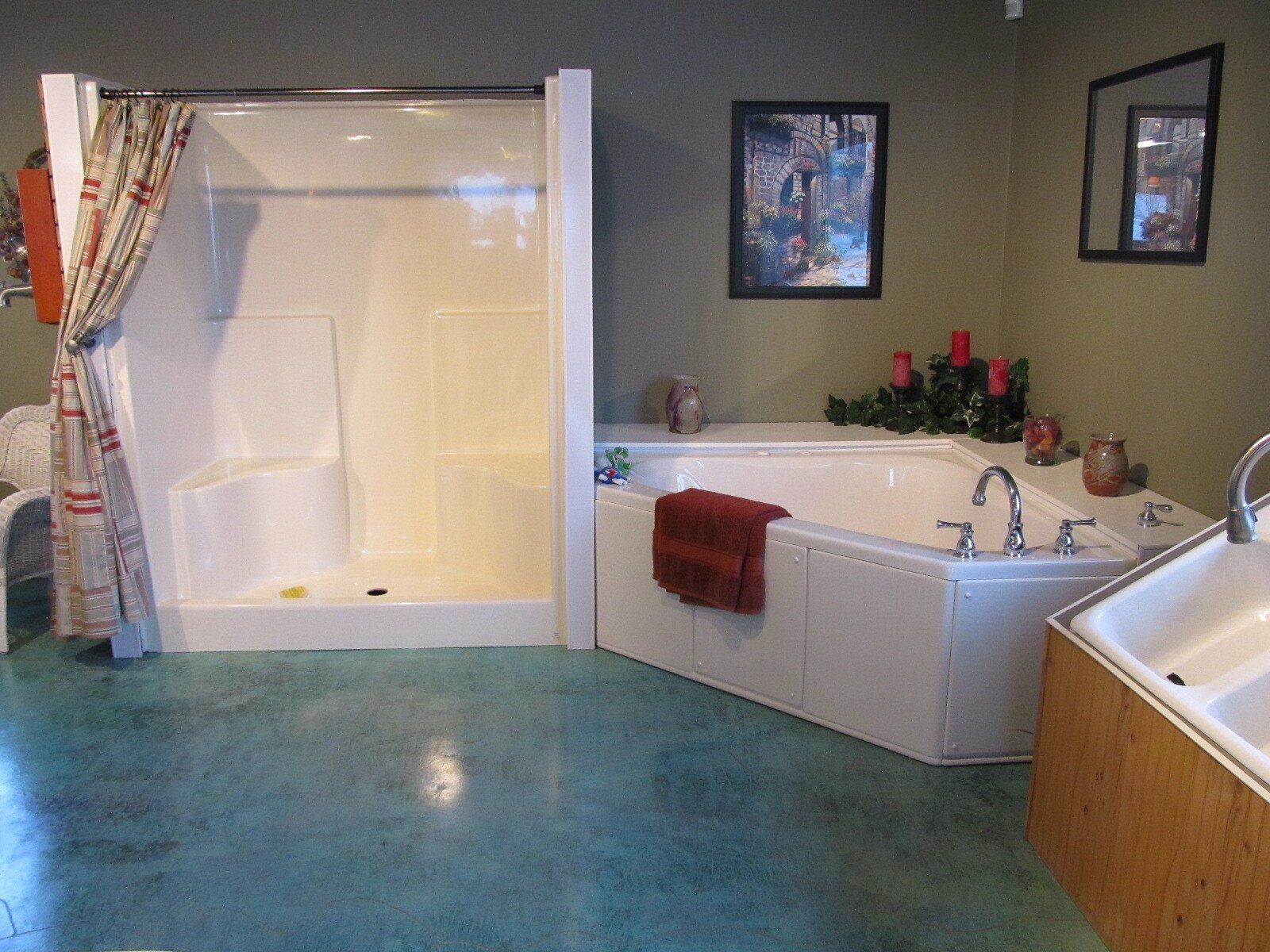 Bathroom with blue floor, white tub, shower stall, and corner soaking tub with red towels.