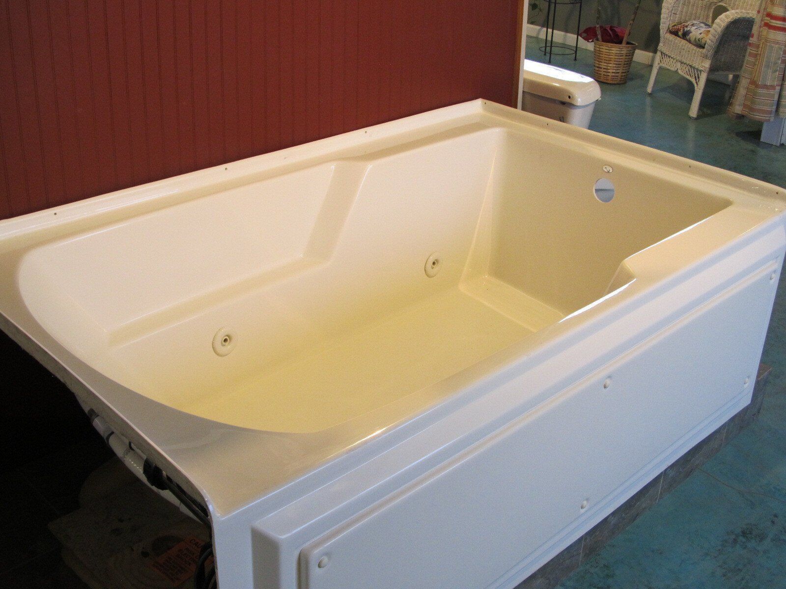 White freestanding bathtub with cream interior in a bathroom showroom