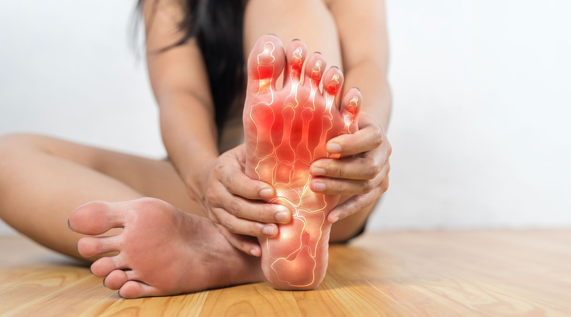 Woman sitting, holding foot with pain. Red highlighted foot showing pain areas.