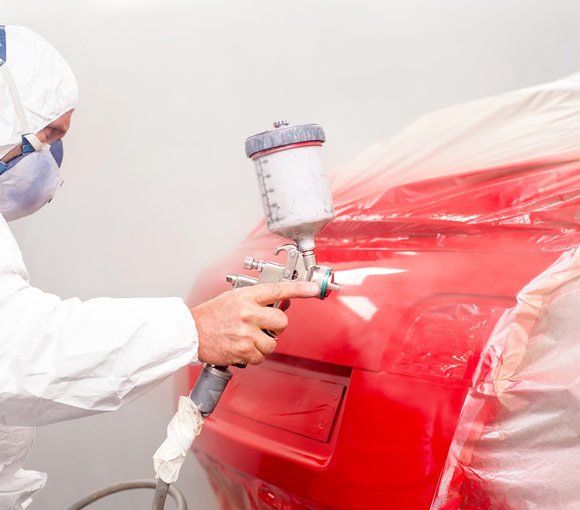 Auto Painter Spraying Red Paint — Powder coating service in Gosford, NSW