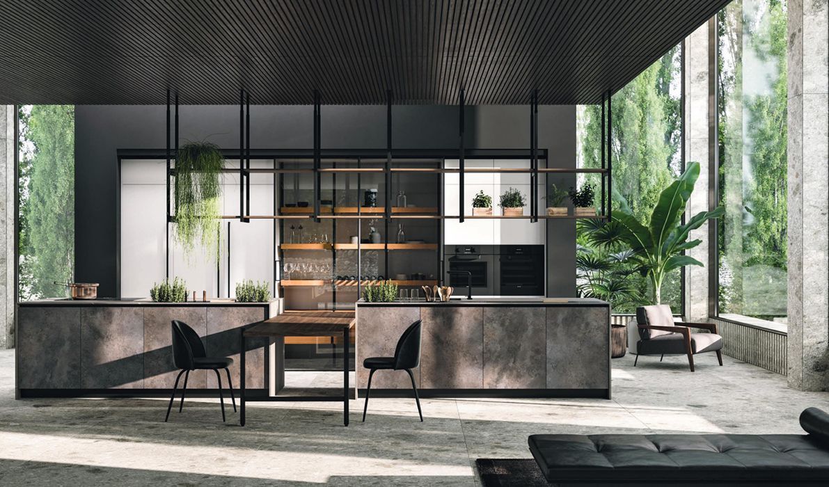 Cucina moderna con mobili scuri, isola in cemento e verde, situata in uno spazio aperto con ampie finestre.