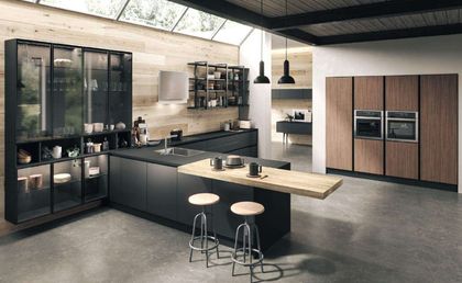 Cucina moderna con mobili scuri, dettagli in legno e isola con sgabelli.