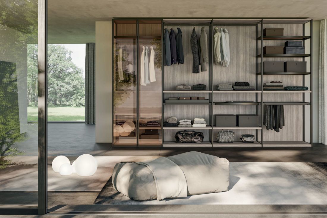 Cabina armadio con vestiti e ripiani; design moderno, toni chiari e scuri. Porta a vetri con vista sull'esterno.
