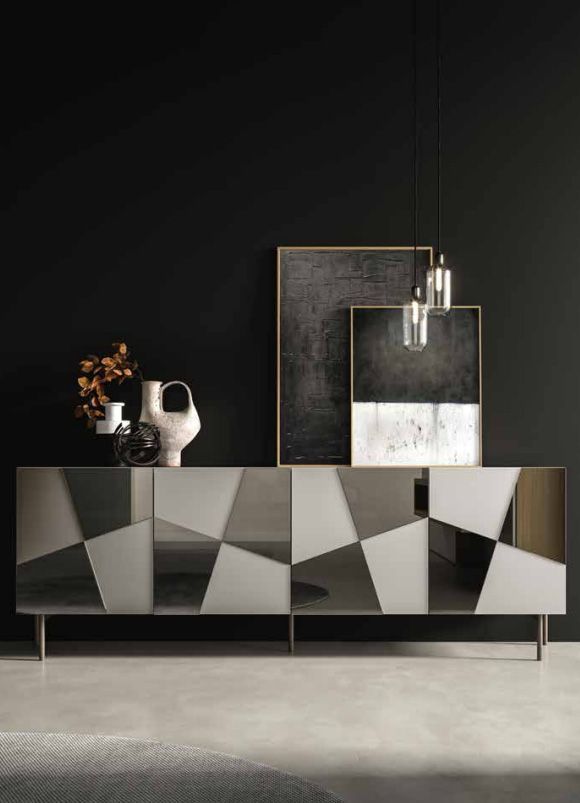 Credenza moderna con design geometrico, appoggiata a una parete scura, con opere d'arte e vasi.