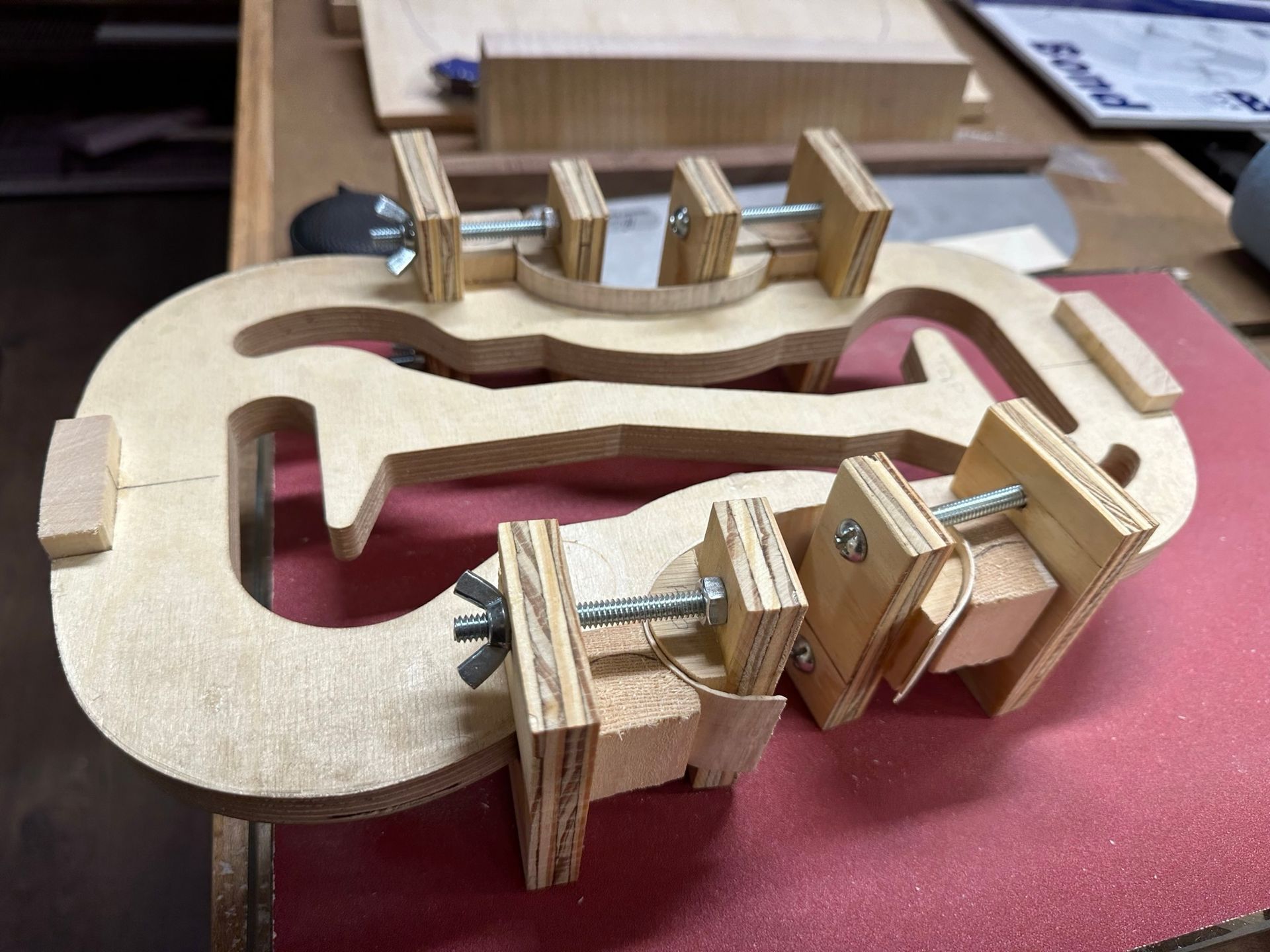 A wooden clamp is sitting on a red surface