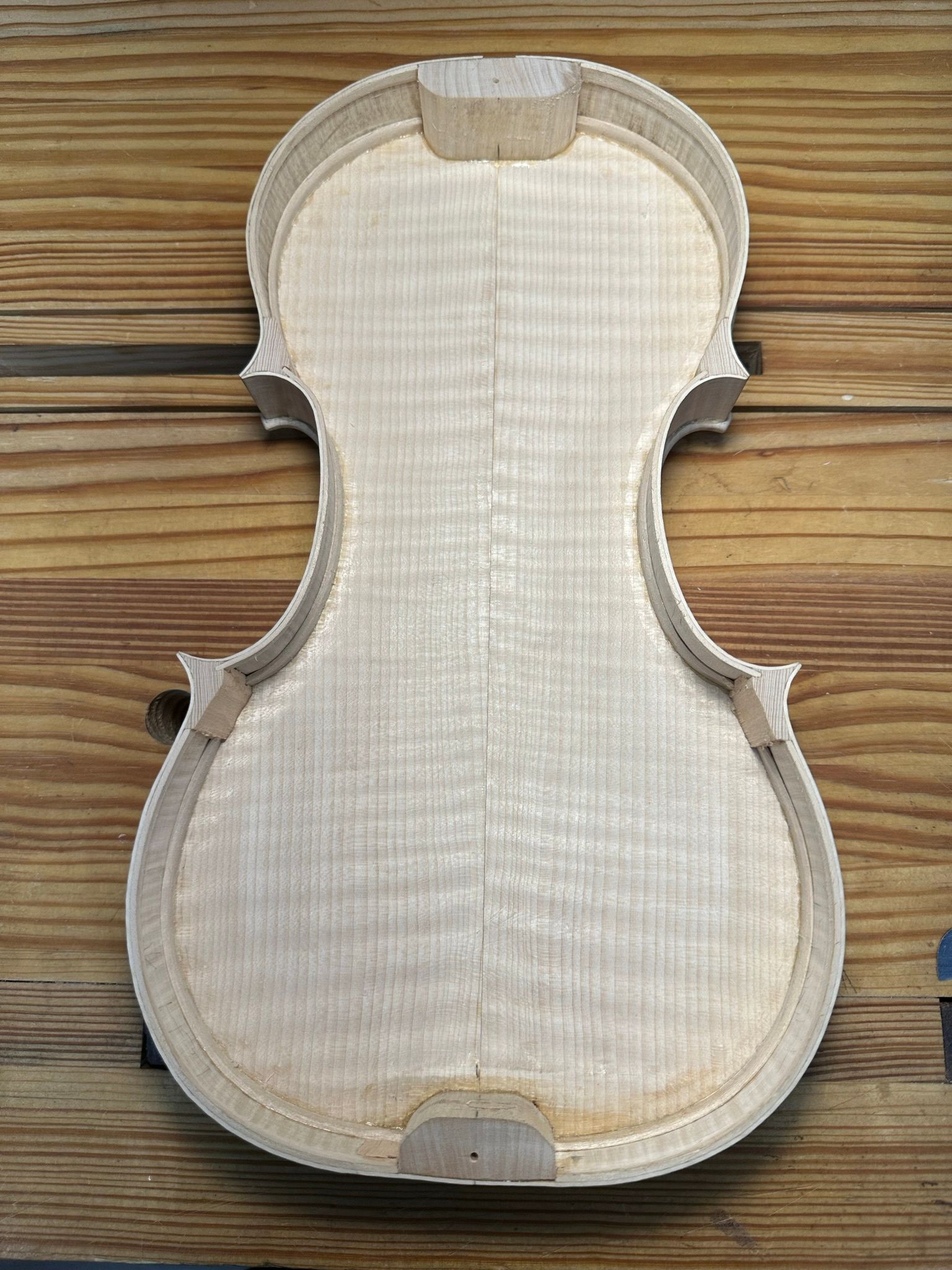A wooden violin is sitting on a wooden table