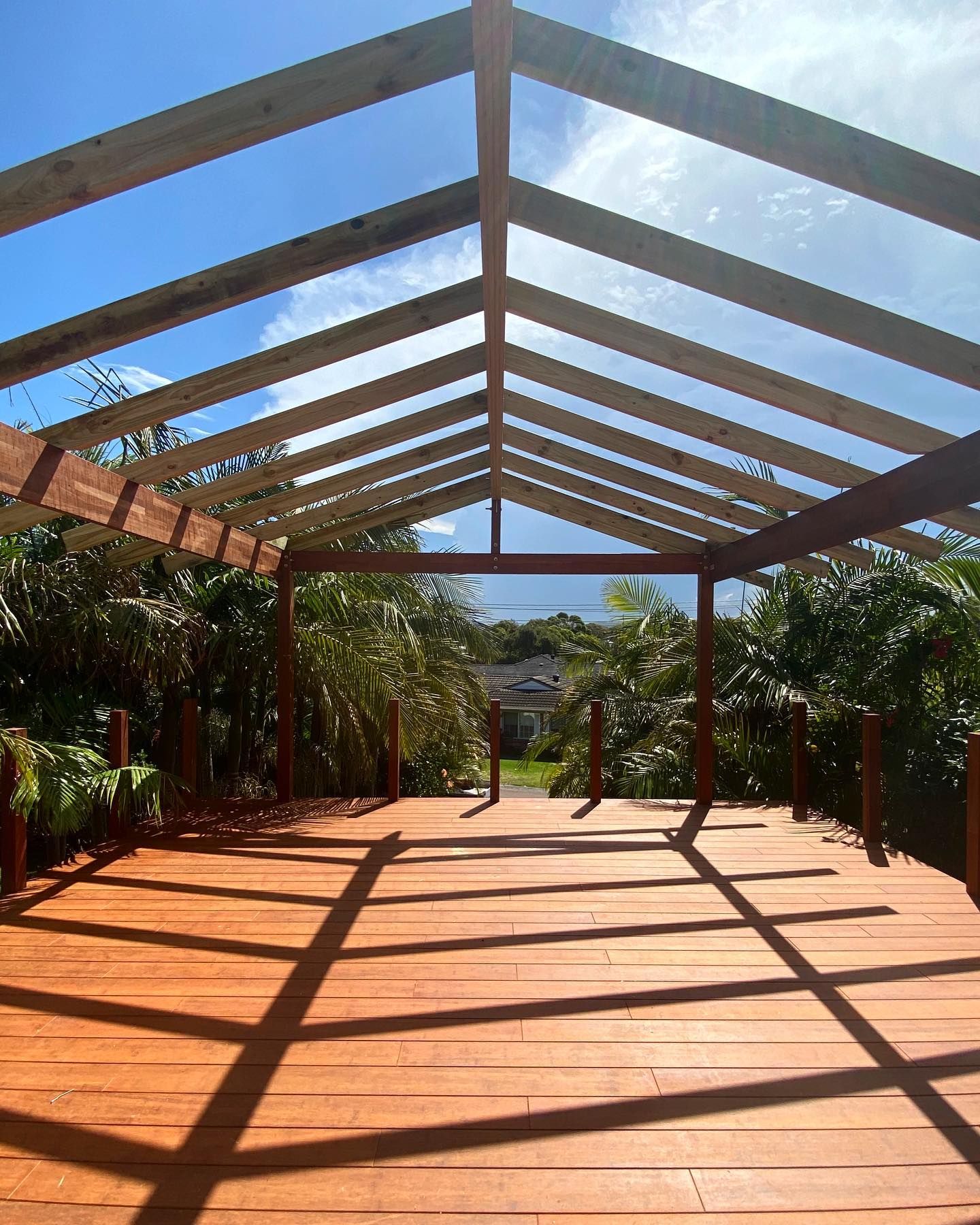 Wooden walkway with beams and roof, leading towards greenery under a sunny sky. — Blue Horizon Projects in Bateau Bay, NSW