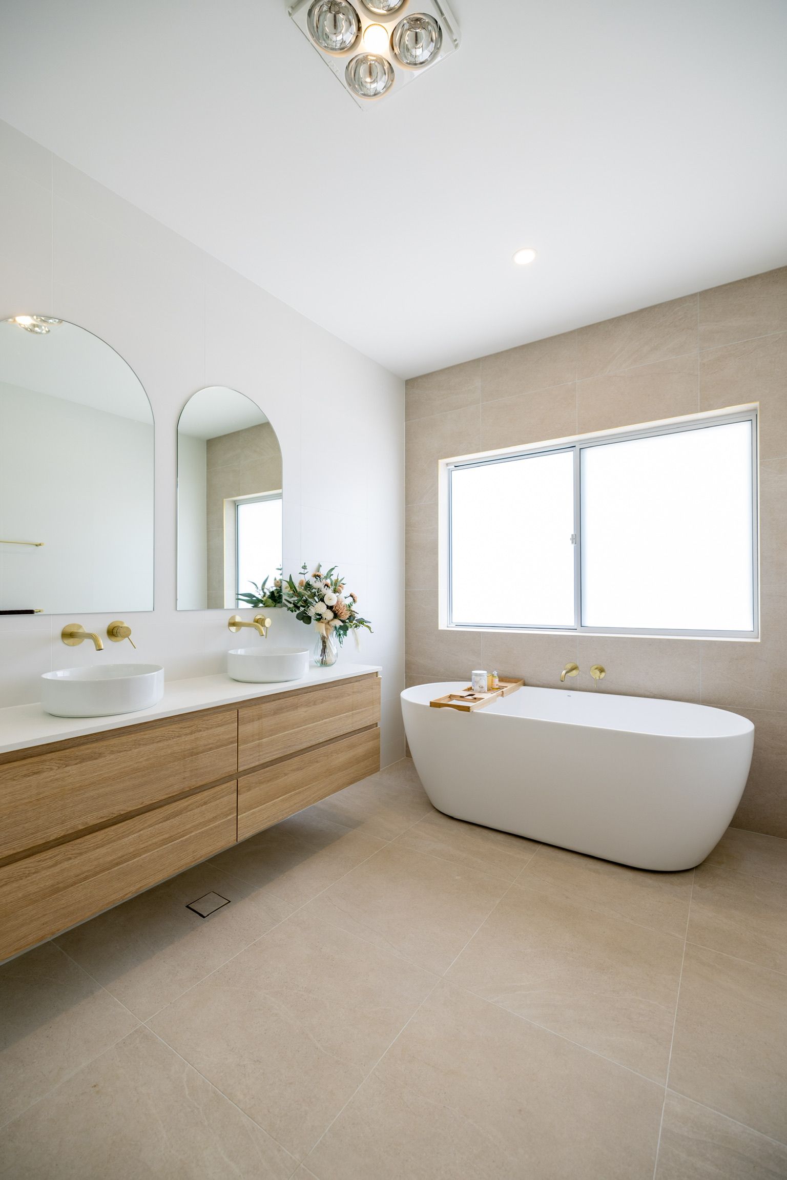 Bright bathroom with soaking tub, double vanity, and large window. — Blue Horizon Projects in Bateau Bay, NSW