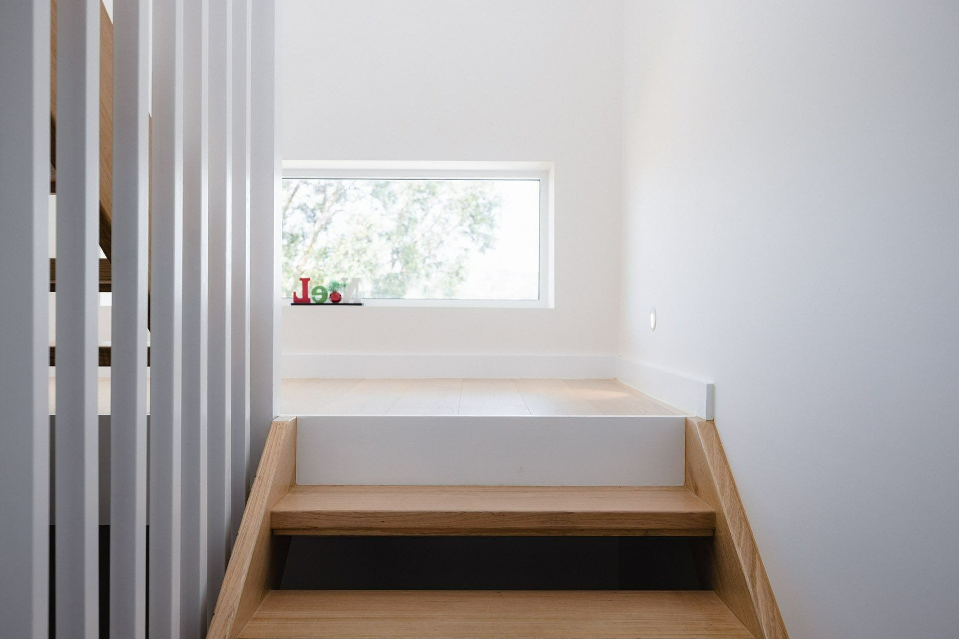 A Wooden Staircase Leading up To a Window in A House — Blue Horizon Projects in Forresters Beach, NSW