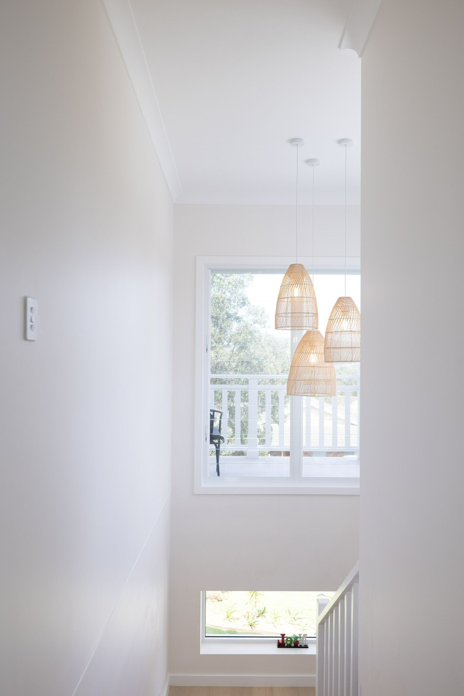 Bright hallway with neutral walls, a window, and pendant lights. — Blue Horizon Projects in Berkeley Vale, NSW