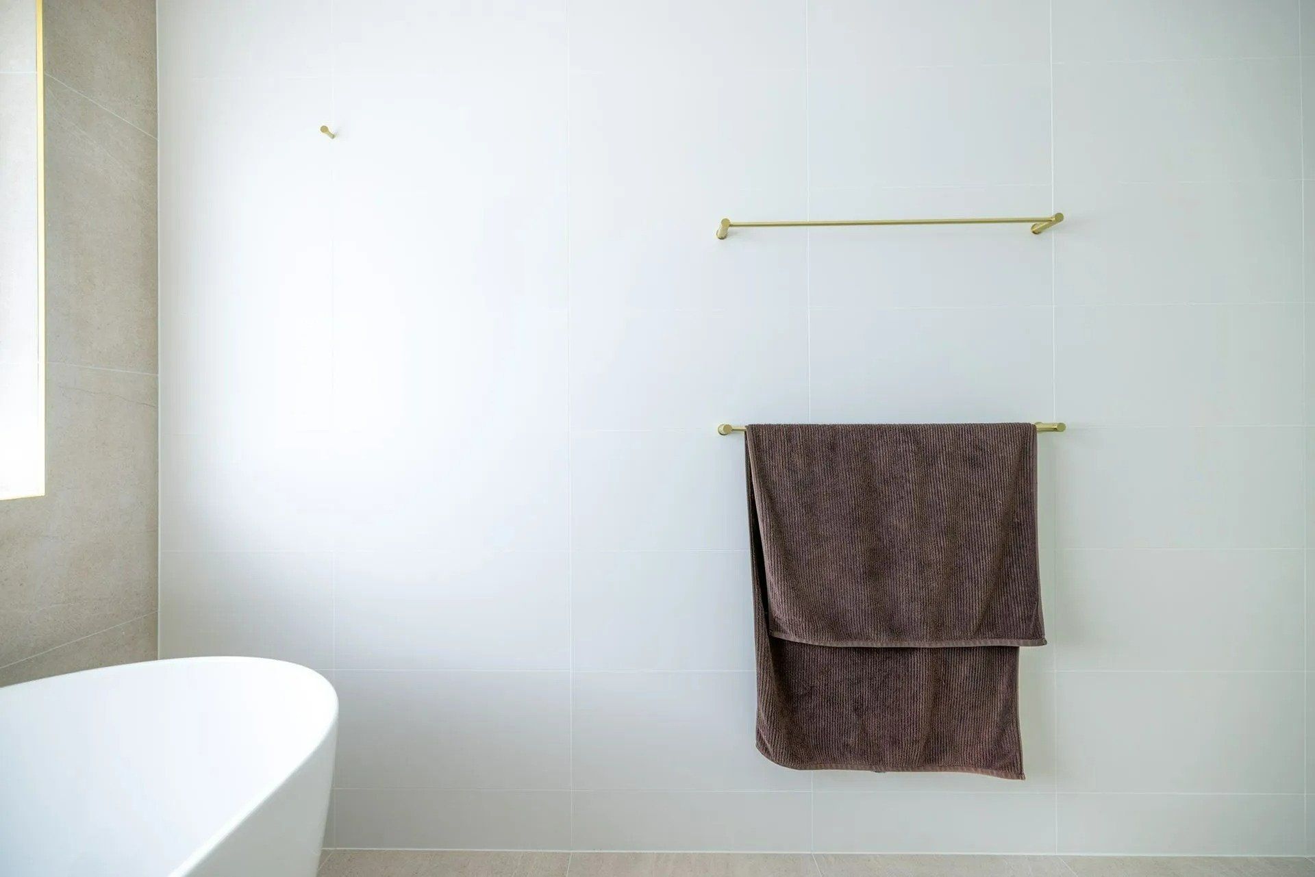 A Towel Is Hanging on A Towel Rack in A Bathroom Next to A Bathtub — Blue Horizon Projects in Hunter Valley, NSW