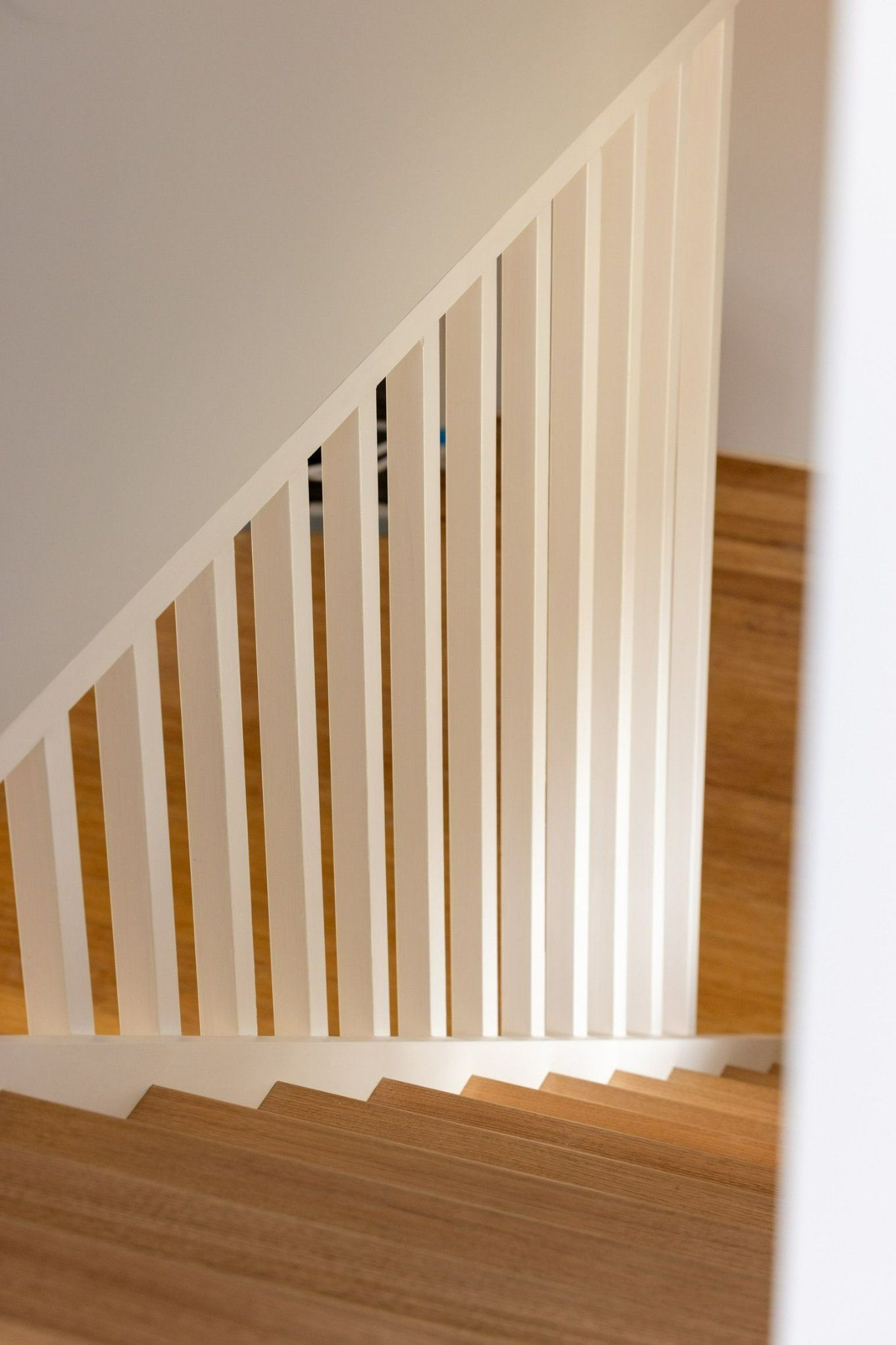 A Close up Of a Wooden Staircase with A White Railing — Blue Horizon Projects in Terrigal, NSW