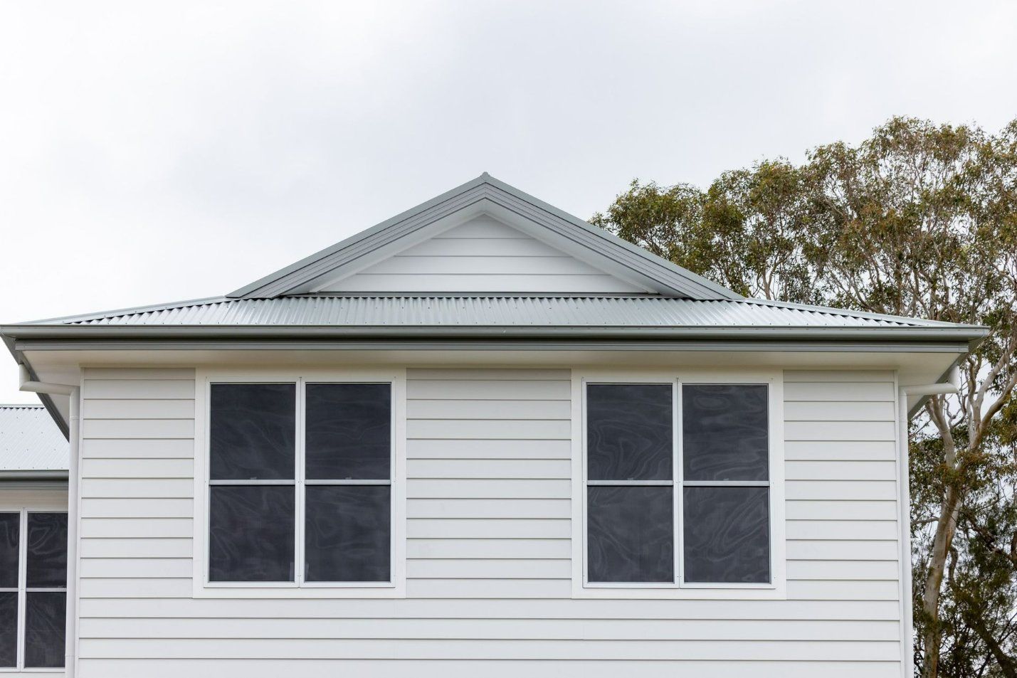 A White House with A Blue Roof and Black Windows — Blue Horizon Projects in Terrigal, NSW