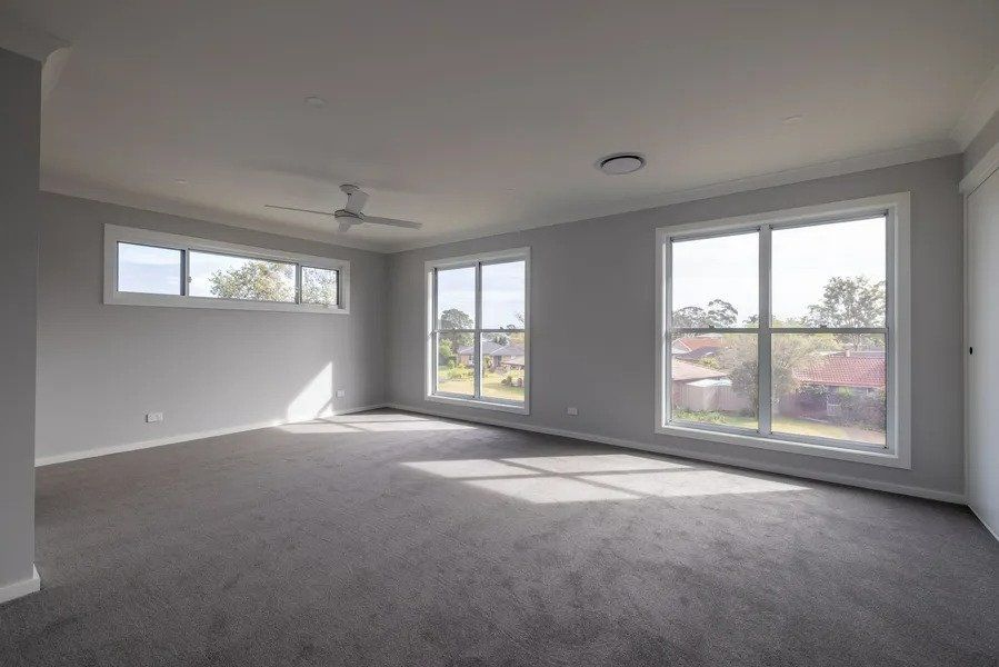 An Empty Living Room with A Lot of Windows and A Ceiling Fan — Blue Horizon Projects in Terrigal, NSW