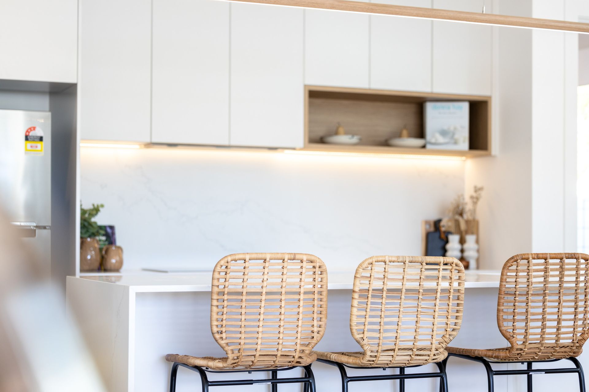 Three Wicker Chairs Are Sitting at A Kitchen Counter — Blue Horizon Projects in Killarney Vale, NSW